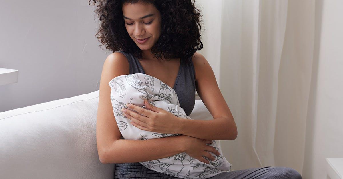 Mom holding baby wrapped in Nest Designs' swaddle blankie