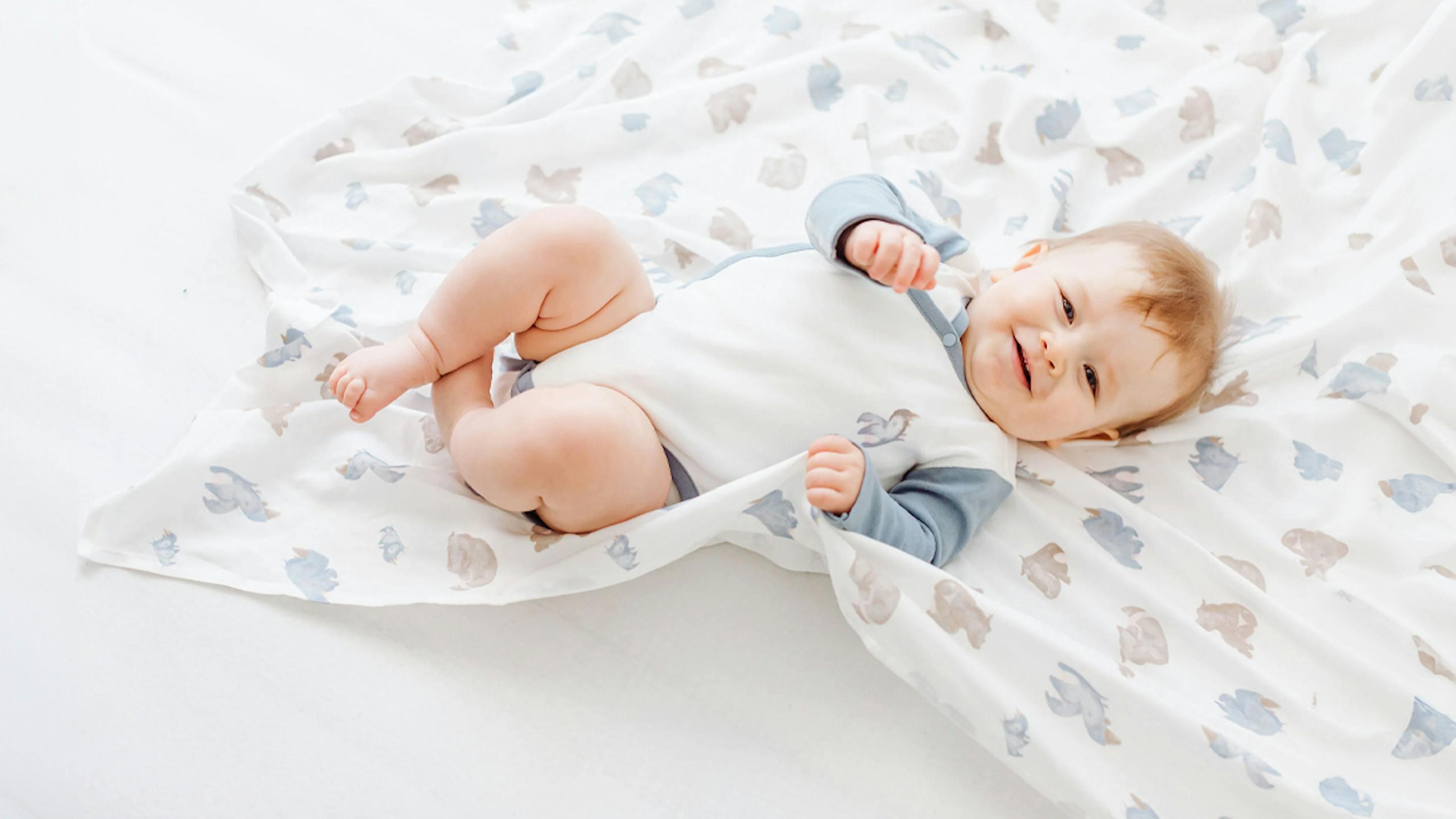 Baby laying on a Nest Designs receiving blanket 