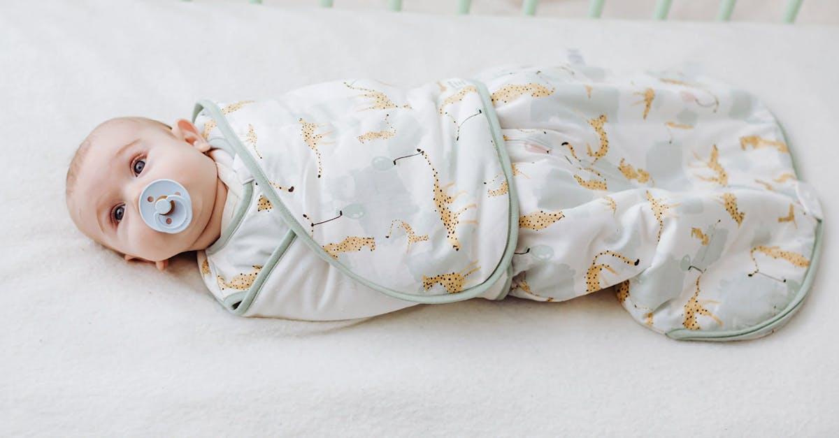 Newborn baby sleeping soundly in Nest Designs' swaddle sleep bag