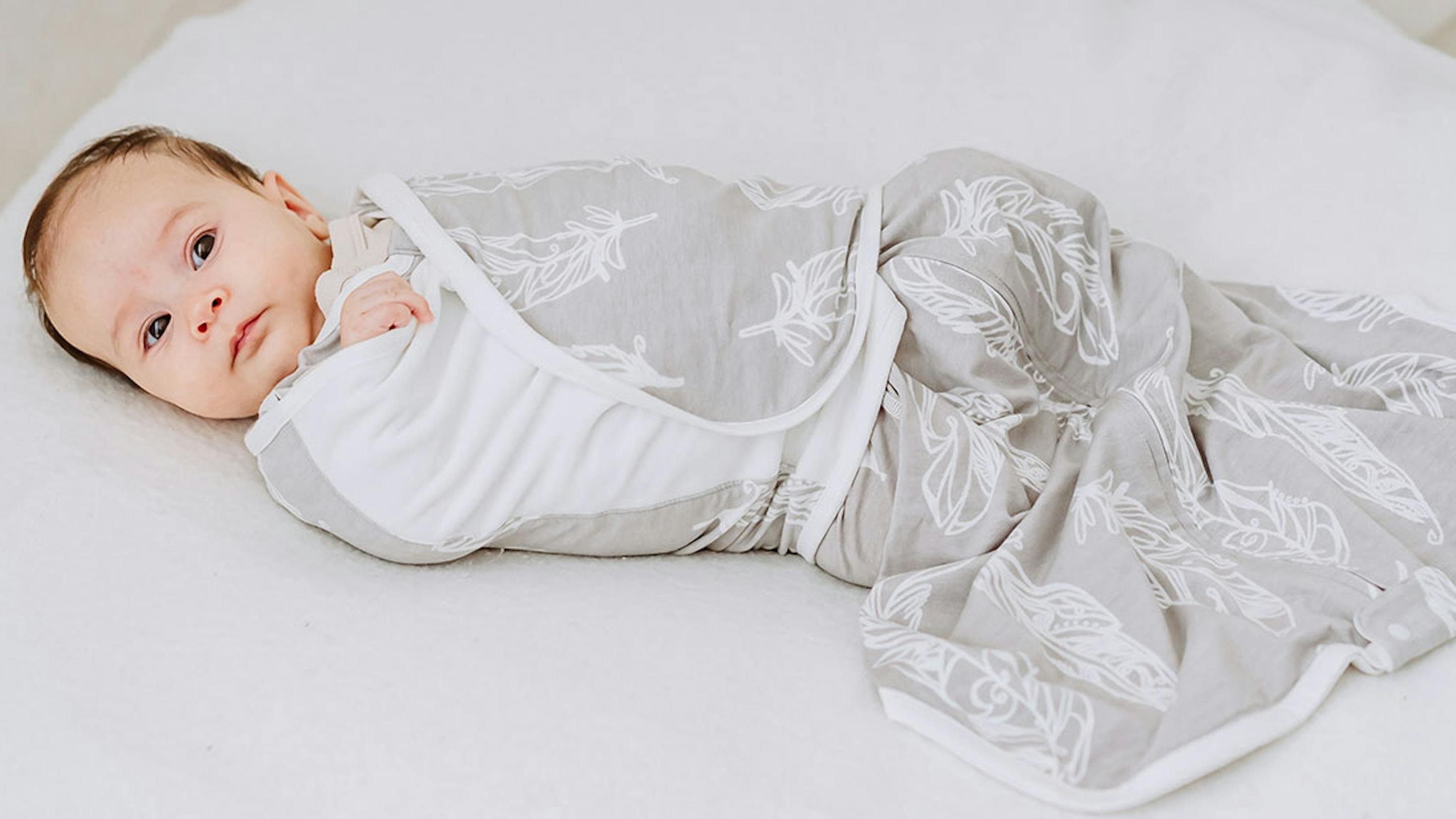 Newborn baby wearing Nest Designs swaddle sleep bag