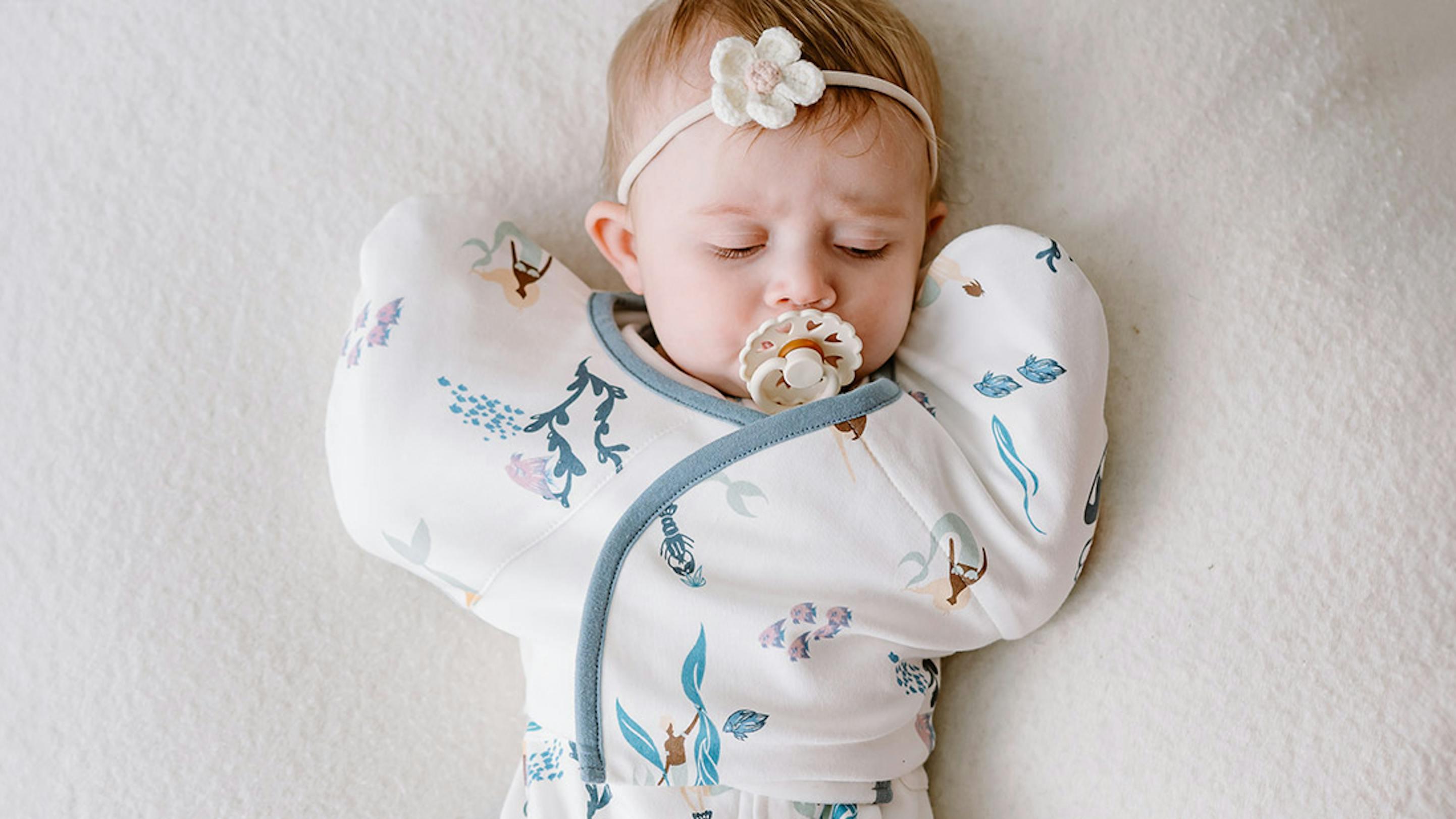 Newborn baby in Nest Designs' startle stop sleep bag